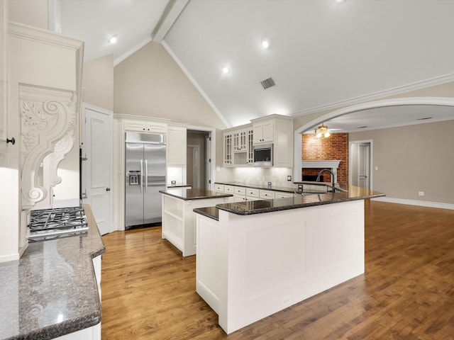901 Saint James Dr, Fairview, TX 75069 - kitchen featuring built in appliances, arched walkways, a center island, a sink, and backsplash