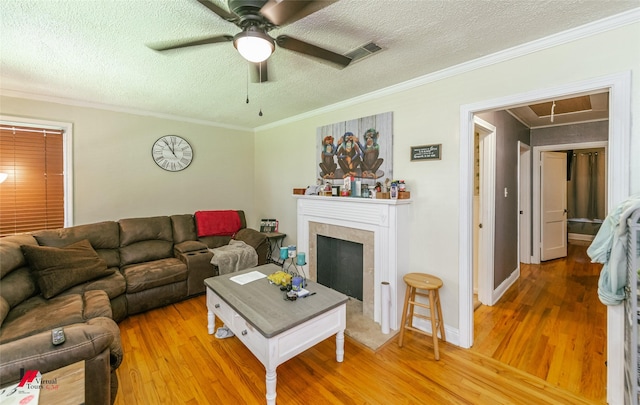 236 Leland Dr, Shreveport, LA 71105 - living area featuring wood finished floors, attic access, ceiling fan, a textured ceiling, and a tiled fireplace