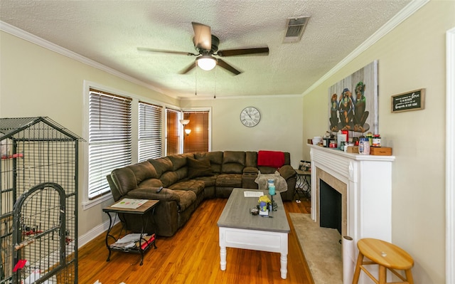 236 Leland Dr, Shreveport, LA 71105 - living room featuring ceiling fan, a textured ceiling, wood finished floors, crown molding, and a premium fireplace