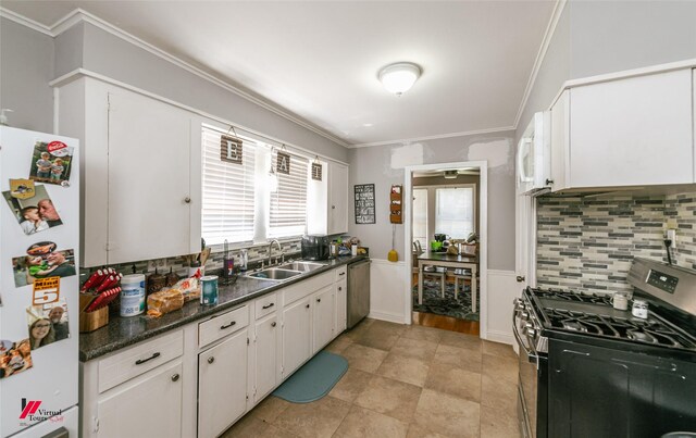 236 Leland Dr, Shreveport, LA 71105 - kitchen featuring appliances with stainless steel finishes, a sink, decorative backsplash, white cabinetry, and dark countertops