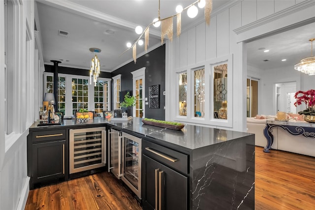 417 Windwood Ct, Mckinney, TX 75071 - indoor wet bar featuring beverage cooler, crown molding, dark wood-style floors, and decorative light fixtures