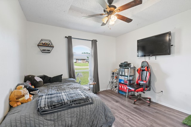 2521 Trail Tree Ct, Burleson, TX 76028 - bedroom with wood finished floors, baseboards, a ceiling fan, and a textured ceiling