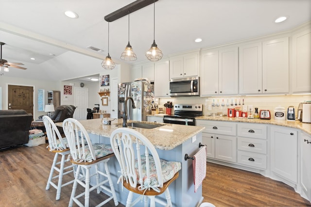 2521 Trail Tree Ct, Burleson, TX 76028 - kitchen with stainless steel appliances, a sink, a kitchen bar, open floor plan, and dark wood-style floors