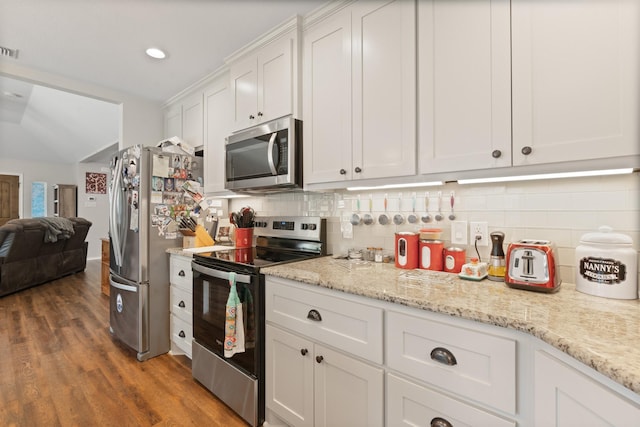 2521 Trail Tree Ct, Burleson, TX 76028 - kitchen featuring appliances with stainless steel finishes, white cabinetry, tasteful backsplash, wood finished floors, and lofted ceiling
