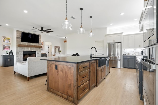 120 Crosswind Trl, Ovalo, TX 79541 - kitchen featuring appliances with stainless steel finishes, crown molding, a sink, a ceiling fan, and light wood-style flooring