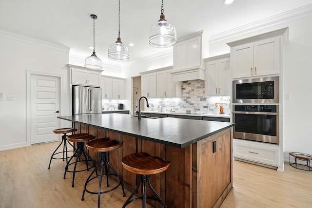 120 Crosswind Trl, Ovalo, TX 79541 - kitchen featuring appliances with stainless steel finishes, a sink, dark countertops, decorative backsplash, and a kitchen island with sink