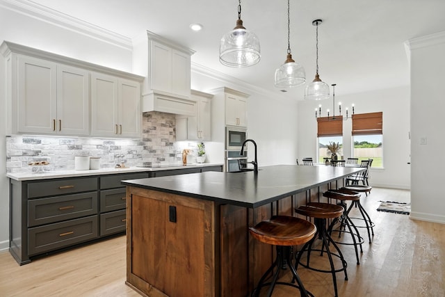 120 Crosswind Trl, Ovalo, TX 79541 - kitchen featuring stainless steel appliances, tasteful backsplash, a center island with sink, light wood-type flooring, and a kitchen breakfast bar