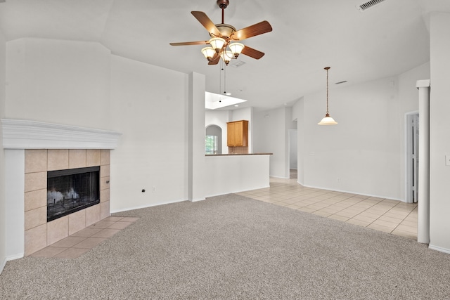 1060 Knightsbridge Dr, Frisco, TX 75036 - unfurnished living room featuring ceiling fan, light carpet, light tile patterned floors, and a tiled fireplace