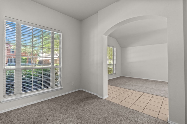 1060 Knightsbridge Dr, Frisco, TX 75036 - spare room featuring carpet, arched walkways, tile patterned flooring, baseboards, and lofted ceiling