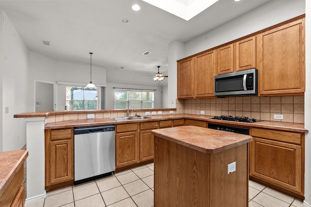 1060 Knightsbridge Dr, Frisco, TX 75036 - kitchen with appliances with stainless steel finishes, a sink, light tile patterned flooring, backsplash, and a peninsula
