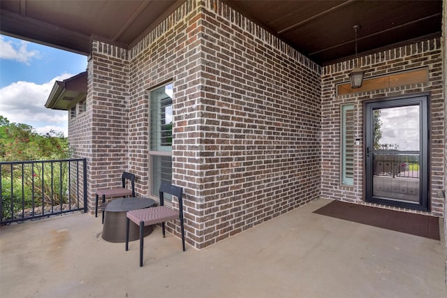 doorway to property featuring brick siding and a patio