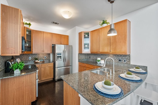 2544 Wedglea Dr, Dallas, TX 75211 - kitchen with stainless steel fridge, a sink, a peninsula, dark stone countertops, and backsplash