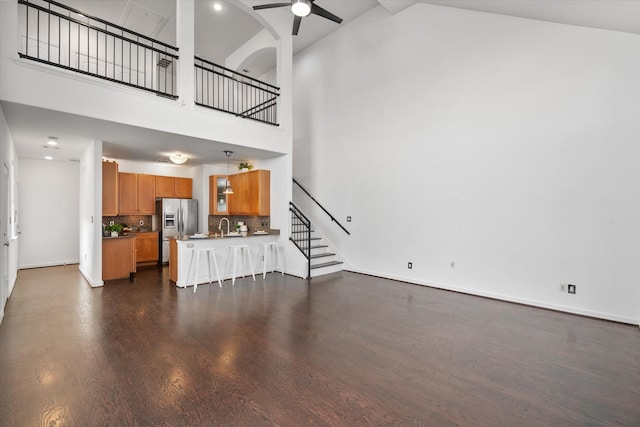 2544 Wedglea Dr, Dallas, TX 75211 - unfurnished living room with ceiling fan, a sink, dark wood-style floors, stairs, and high vaulted ceiling