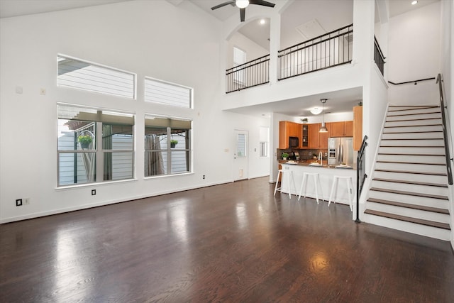 2544 Wedglea Dr, Dallas, TX 75211 - unfurnished living room with ceiling fan, high vaulted ceiling, stairway, dark wood finished floors, and baseboards