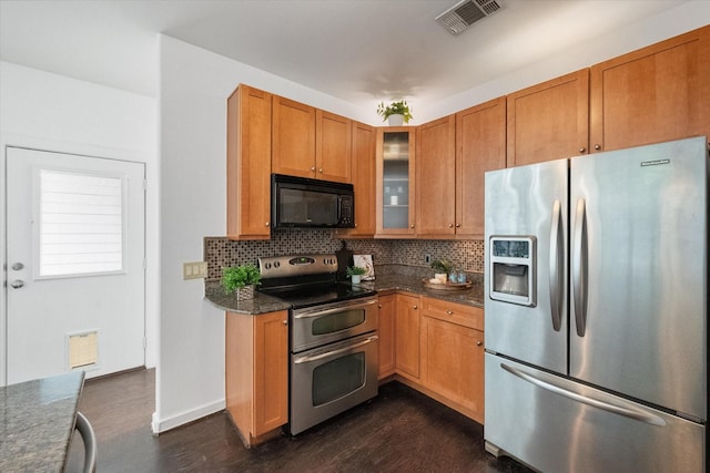 2544 Wedglea Dr, Dallas, TX 75211 - kitchen with appliances with stainless steel finishes, dark wood-type flooring, decorative backsplash, glass insert cabinets, and brown cabinetry