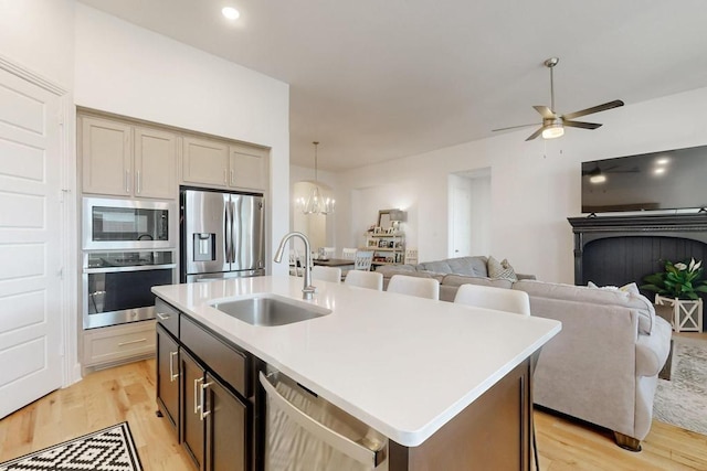 1033 Falls Rush Way, Royse City, TX 75189 - kitchen featuring stainless steel appliances, a sink, light wood-style flooring, and open floor plan