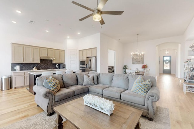 1033 Falls Rush Way, Royse City, TX 75189 - living room featuring light wood-type flooring, arched walkways, a ceiling fan, a chandelier, and recessed lighting