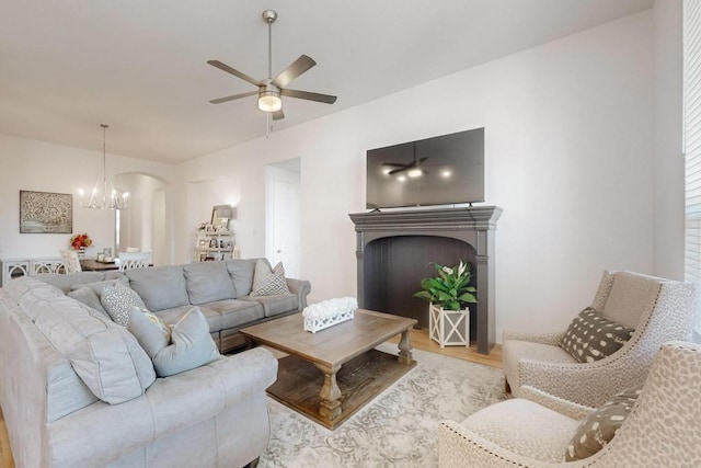 1033 Falls Rush Way, Royse City, TX 75189 - living room with wood finished floors, a chandelier, a ceiling fan, arched walkways, and a fireplace