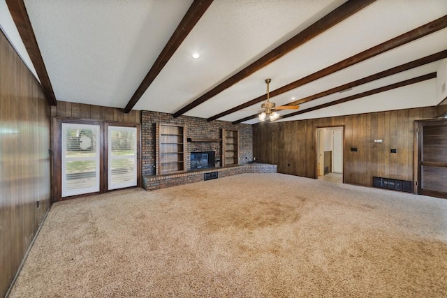 1300 Woodland Trail Dr, Bowie, TX 76230 - unfurnished living room featuring ceiling fan, carpet flooring, a brick fireplace, and wooden walls