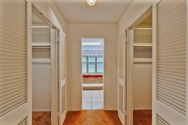 1300 Woodland Trail Dr, Bowie, TX 76230 - hall featuring carpet, a textured ceiling, baseboards, and tile patterned floors