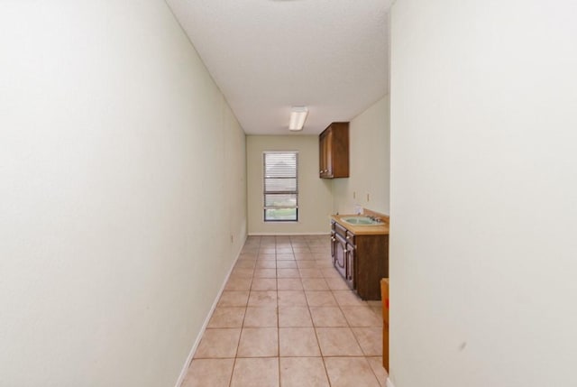 1300 Woodland Trail Dr, Bowie, TX 76230 - hall featuring light tile patterned floors, a sink, and baseboards