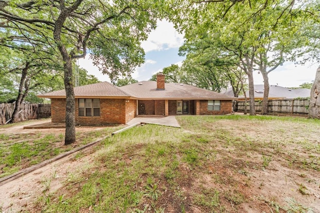1300 Woodland Trail Dr, Bowie, TX 76230 - rear view of house featuring brick siding, a patio, and a chimney