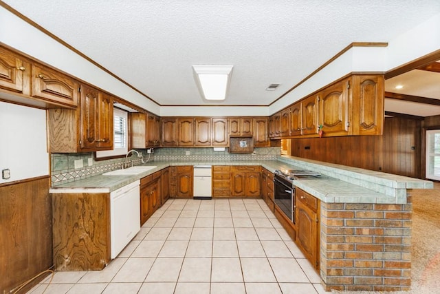 1300 Woodland Trail Dr, Bowie, TX 76230 - kitchen featuring a sink, white dishwasher, brown cabinets, wood walls, and a textured ceiling