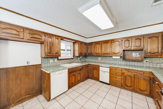 1300 Woodland Trail Dr, Bowie, TX 76230 - kitchen with white dishwasher, a sink, brown cabinetry, a textured ceiling, and ornamental molding