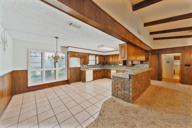 1300 Woodland Trail Dr, Bowie, TX 76230 - kitchen featuring white dishwasher, wooden walls, a chandelier, brown cabinetry, and a sink