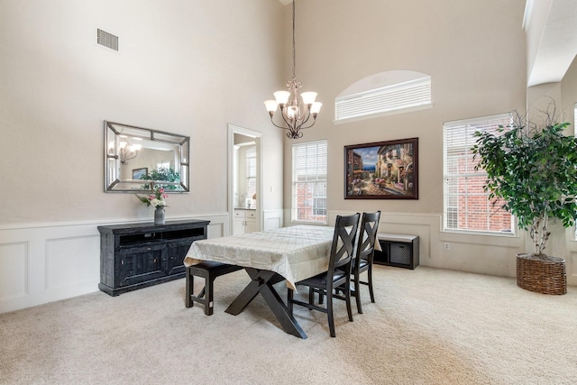 2048 Remington Ln, Frisco, TX 75033 - carpeted dining room with a chandelier, a decorative wall, a wainscoted wall, and a high ceiling