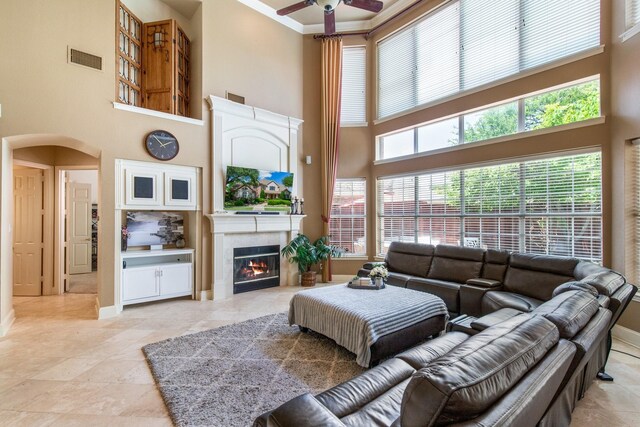 2048 Remington Ln, Frisco, TX 75033 - living area featuring a high ceiling, a ceiling fan, arched walkways, a glass covered fireplace, and baseboards