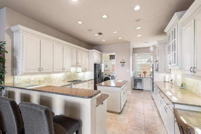 2048 Remington Ln, Frisco, TX 75033 - kitchen featuring stainless steel appliances, beverage cooler, a kitchen island, recessed lighting, and decorative backsplash