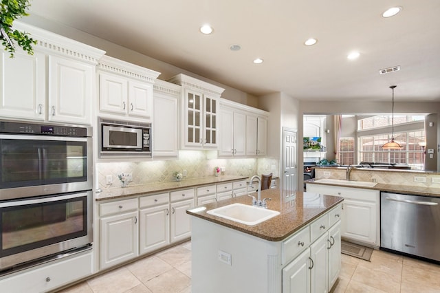 2048 Remington Ln, Frisco, TX 75033 - kitchen featuring appliances with stainless steel finishes, a sink, decorative backsplash, light tile patterned floors, and recessed lighting