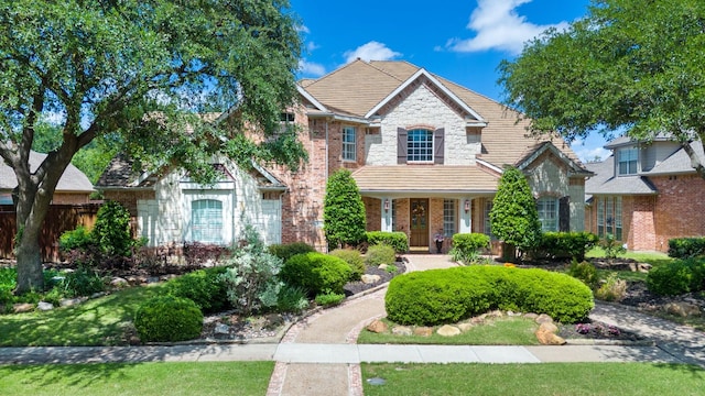 2048 Remington Ln, Frisco, TX 75033 - traditional-style house with brick siding, fence, stone siding, and covered porch
