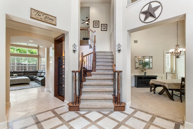2048 Remington Ln, Frisco, TX 75033 - stairs with a high ceiling, baseboards, inlaid floor details, crown molding, and a chandelier