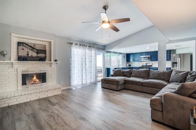 1301 Windy Meadow Dr, Plano, TX 75023 - living room featuring a ceiling fan, vaulted ceiling, wood finished floors, and a fireplace