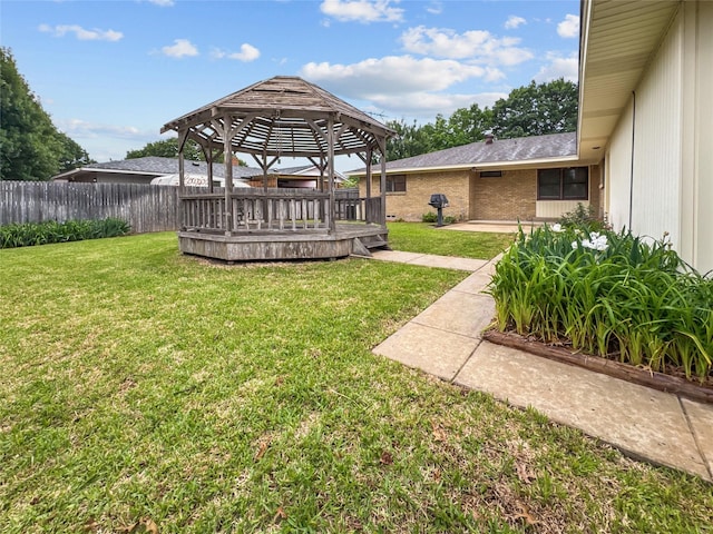 view of yard with a gazebo, a wooden deck, and a patio area
