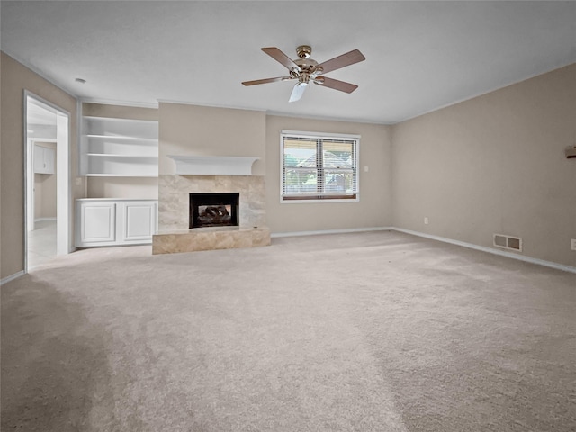 unfurnished living room with baseboards, a fireplace, ceiling fan, and carpet