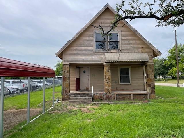 back of house featuring a porch and a lawn