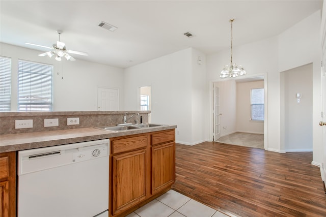 1727 Preston On The Lake Blvd, Little Elm, TX 75068 - kitchen featuring dishwasher, a sink, light wood finished floors, brown cabinetry, and a chandelier