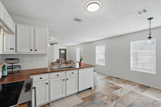 3110 Legend Dr, Mckinney, TX 75070 - kitchen with wood counters, white dishwasher, a sink, white cabinetry, and a textured ceiling