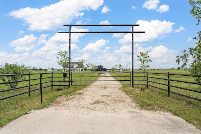 1197 Prairie Chapel Rd, Crawford, TX 76638 - view of dirt / gravel driveway featuring a gate, a view of rural / pastoral area, and a gated entry