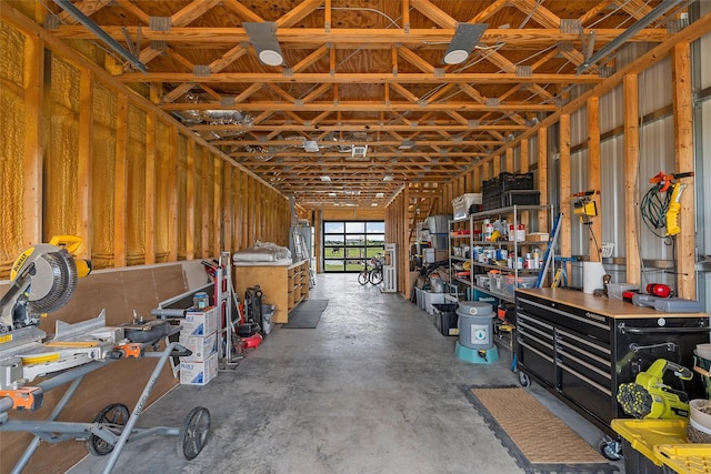 1197 Prairie Chapel Rd, Crawford, TX 76638 - miscellaneous room with unfinished concrete floors, a workshop area, a garage, and water heater