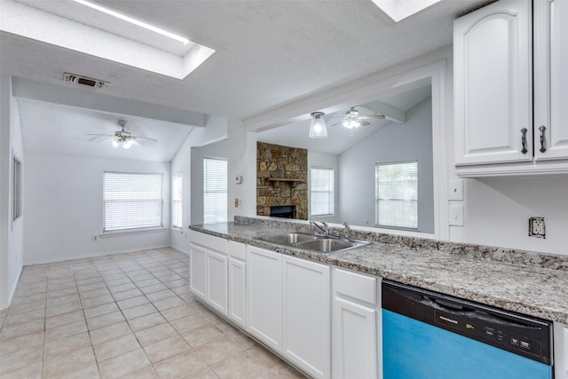 kitchen featuring dishwasher, a sink, a ceiling fan, open floor plan, and light tile patterned flooring
