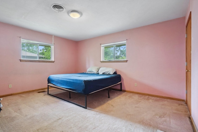 carpeted bedroom with multiple windows and baseboards
