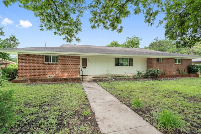 ranch-style home with a front lawn, board and batten siding, and brick siding