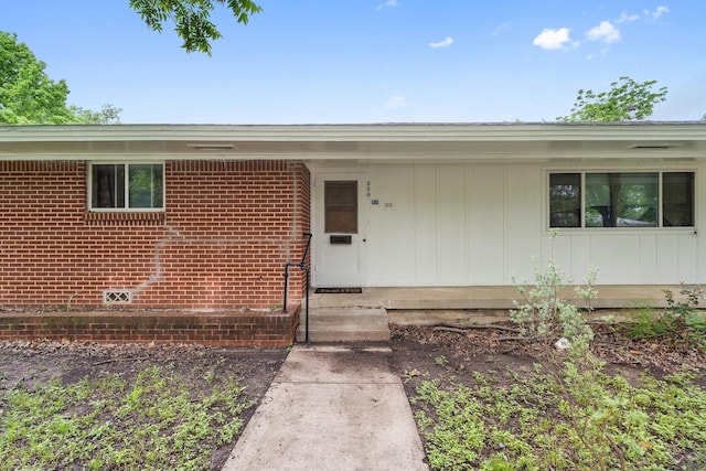view of exterior entry featuring brick siding