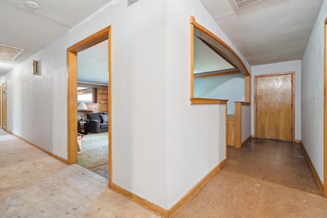 corridor featuring baseboards and tile patterned floors