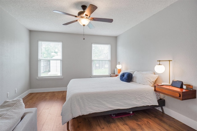 5012 Marina Del Rd, Fort Worth, TX 76179 - bedroom with multiple windows, hardwood / wood-style flooring, a textured ceiling, baseboards, and a ceiling fan
