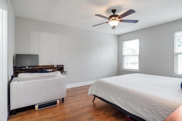 5012 Marina Del Rd, Fort Worth, TX 76179 - bedroom with wood finished floors, multiple windows, baseboards, a textured ceiling, and ceiling fan